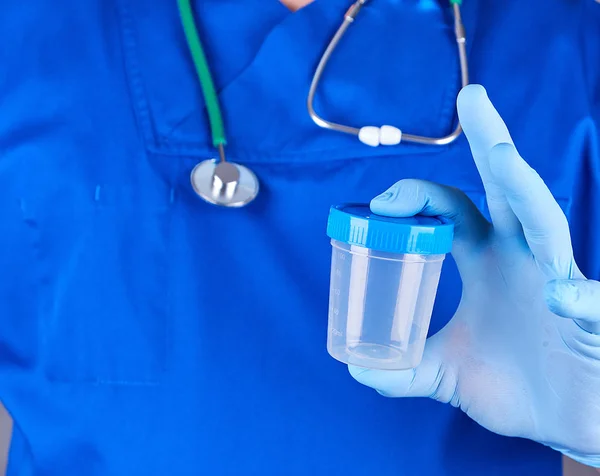 Lékař v modré jednotné a latexové rukavice drží prázdná — Stock fotografie