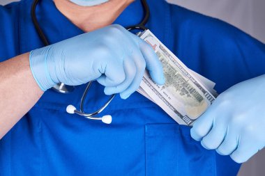 erkek doktor bir tomar dolar gömlek cebinde, kavramı o koyar.