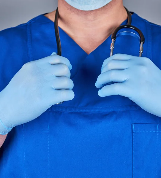 Arzt in blauer Uniform und alten Latex-Handschuhen mit einer schwarzen — Stockfoto