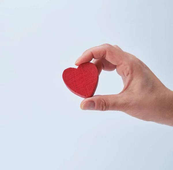 Corazón rojo en una mano humana sobre fondo blanco —  Fotos de Stock