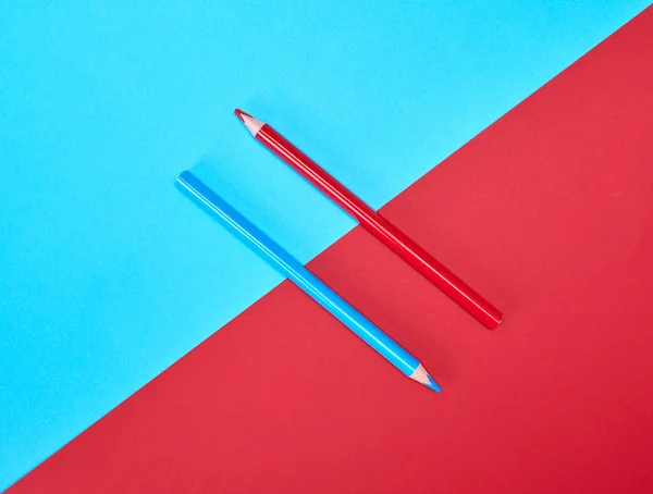 红色和蓝色木制铅笔在颜色抽象背景 — 图库照片