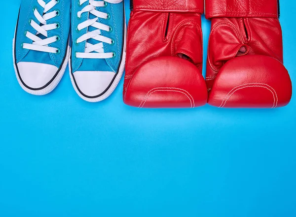 Červené Boxerské rukavice a modré textilní tenisky — Stock fotografie