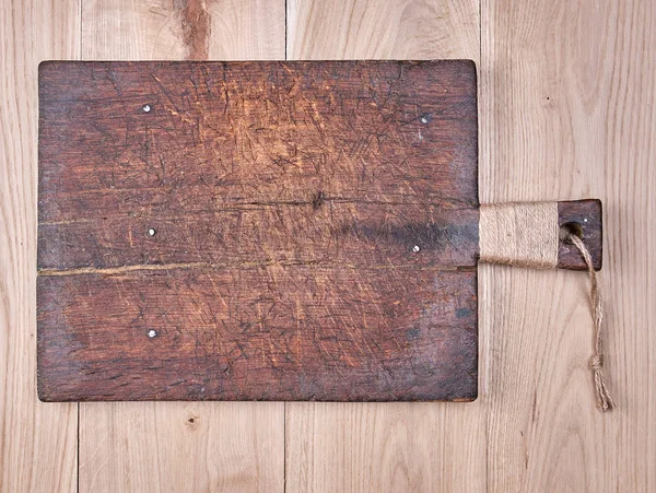 Placa de corte quadrado marrom muito velho com uma alça — Fotografia de Stock