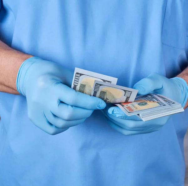 Médico de uniforme azul e luvas conta dinheiro — Fotografia de Stock