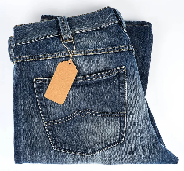 Gefaltete blaue Jeans und gebundene braune Blanko-Tags — Stockfoto