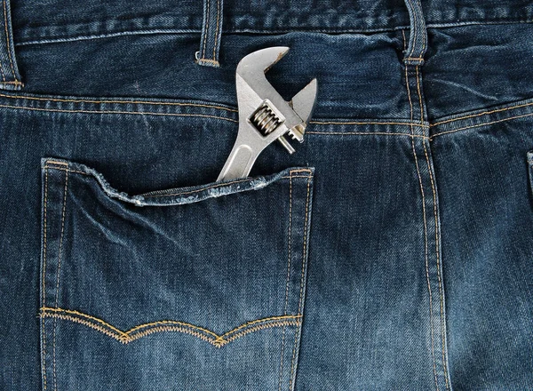 Metal adjustable wrench in blue jeans back pocket — Stock Photo, Image