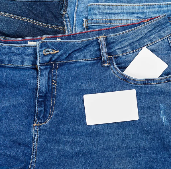 Empty paper card lies on blue jeans Stock Photo