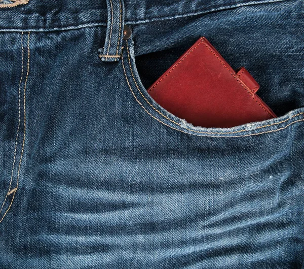 Brown leather wallet in the front pocket of blue jeans — Stock Photo, Image