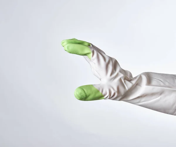 Mano en un guante de goma blanco-verde — Foto de Stock