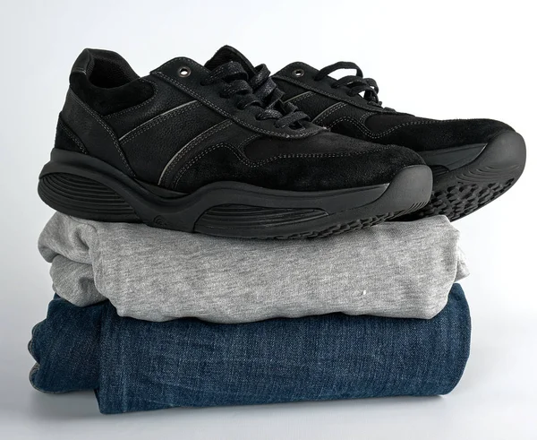 Stapel Kleidung Jeans, Pullover und schwarze Herrenschuhe — Stockfoto