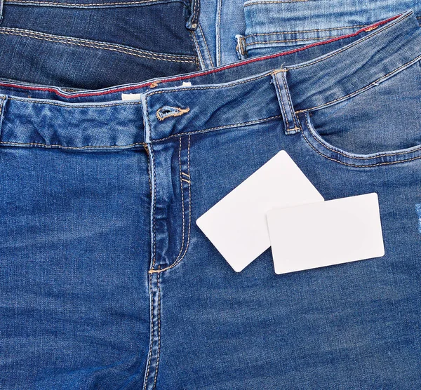 Порожня паперова картка лежить на блакитних джинсах — стокове фото