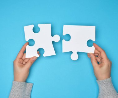 büyük kağıt beyaz boş bulmacalar tutan iki eller 