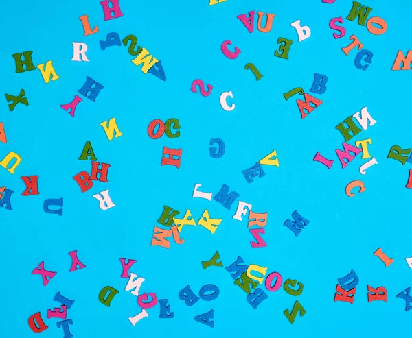 Mehrfarbige Buchstaben des englischen Alphabets auf blauem Hintergrund — Stockfoto