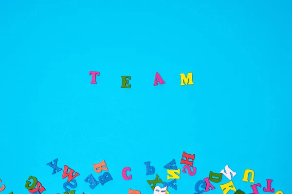 Sana joukkue monivärisiä kirjaimia sinisellä taustalla — kuvapankkivalokuva