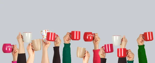 Many raised hands up with ceramic cups on a white background — Stock Photo, Image