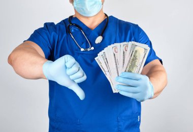 Doktor mavi üniforma ve lateks eldiven bir yandan çok tutar. 