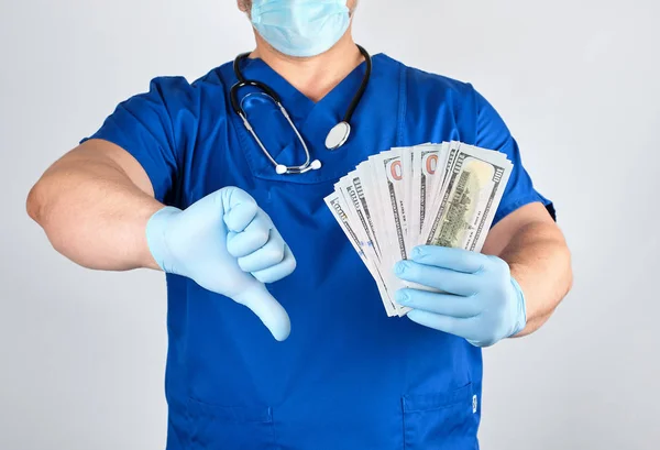 Médico de uniforme azul e luvas de látex mantém uma mão um monte de — Fotografia de Stock