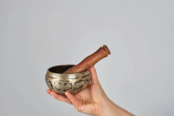 Bol chantant en cuivre et bâton en bois à la main féminine — Photo
