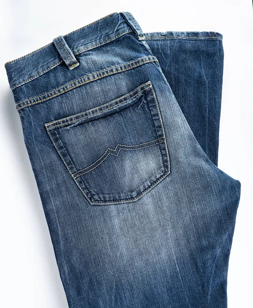 Folded blue men's jeans on a white background — Stock Photo, Image