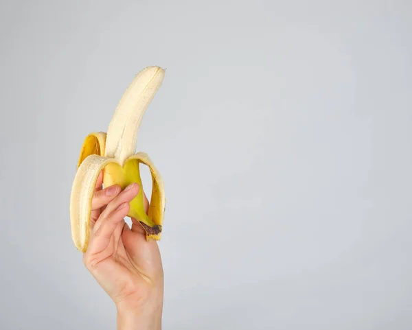 Peeled fresh banana in female hand — Stock Photo, Image