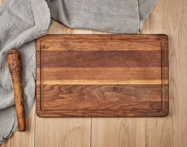 Boş eski ahşap mutfak kesme tahtası ve gri bir havlu 