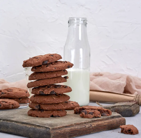 Stack of round chocolate chip cookies on a brown wooden board — Stock Photo, Image