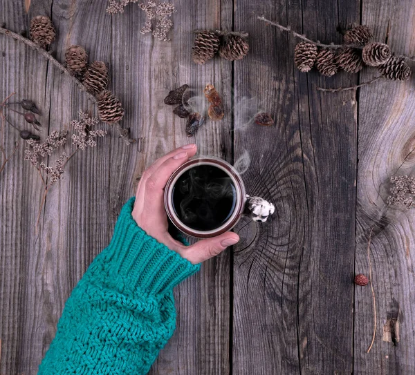 Weibliche Hand in grünem Strickpullover mit Keramikbecher — Stockfoto