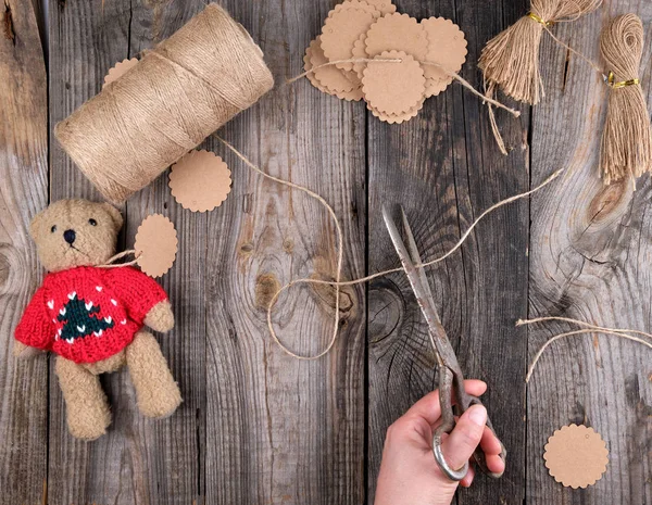 female hands cut brown rope for tags