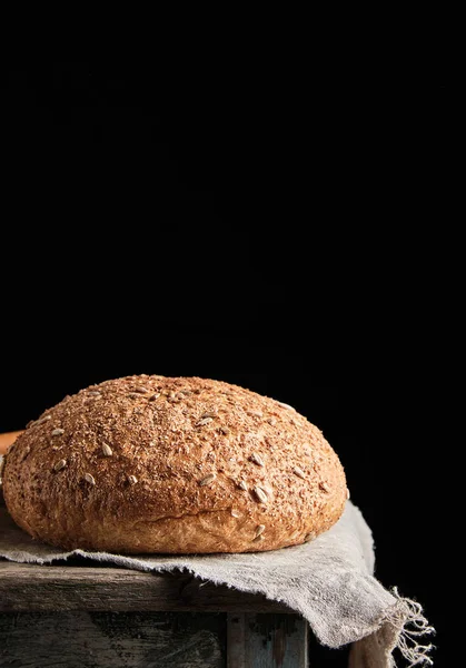 Baked round rye bread lies on a gray linen napkin — Stock Photo, Image