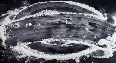 siyah bir masaya dağılmış beyaz buğday unu