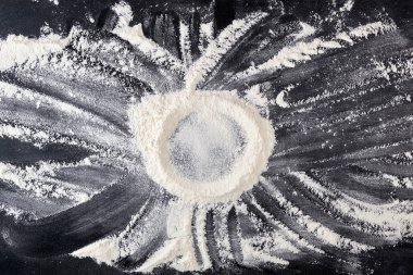 siyah bir masaya dağılmış beyaz buğday unu