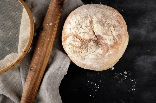 Pão assado redondo e rolo velho de madeira — Fotografia de Stock