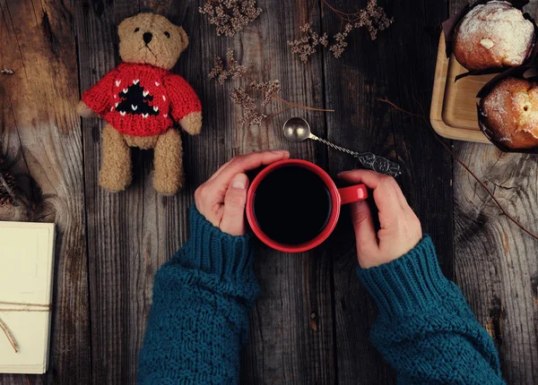 Ręce kobiet w zielonym sweter z dzianiny trzymając czerwony ceramiczny m — Zdjęcie stockowe