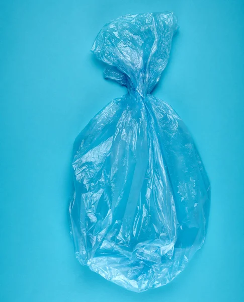Синий пластиковый пакет для мусора на синем фоне — стоковое фото