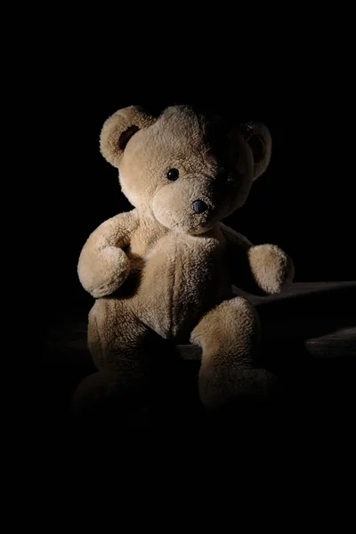 Oude bruine teddybeer zit op een houten oppervlak — Stockfoto