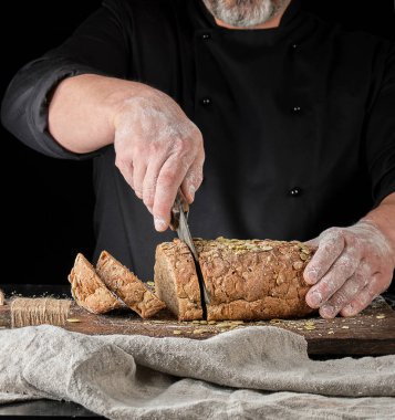 fırıncı kabak çekirdeği ile çavdar ekmeği dilimleri halinde bir bıçak keser 