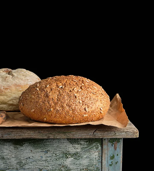 Baked round rye bread lies on a brown paper — Stock Photo, Image