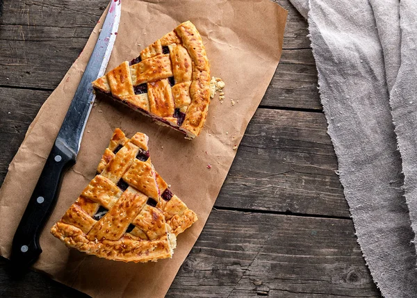 Gâteaux cuits avec une cerise et un couteau de cuisine sont sur papier brun — Photo