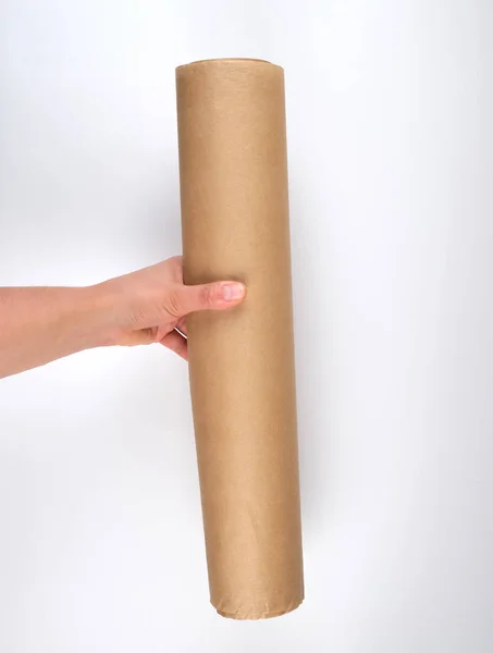 Kézzel tart egy nagy tekercs barna pergamen papír — Stock Fotó