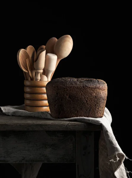 Baked rye bread lies flour on a textile towel, wooden old table — Stock Photo, Image