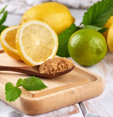 Tahtada kahverengi şekerli ahşap kaşık, limon ve limon, dakika