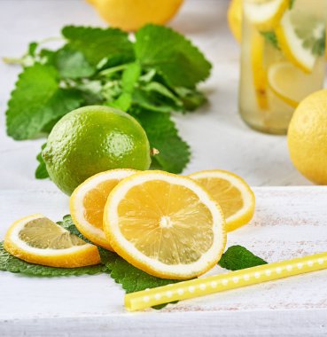 ahşap bir tahta üzerinde taze limon ve limon dilimleri