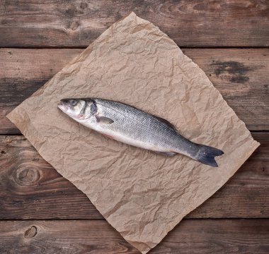 kahverengi buruşturulmuş kağıt üzerinde taze bütün levrek balık