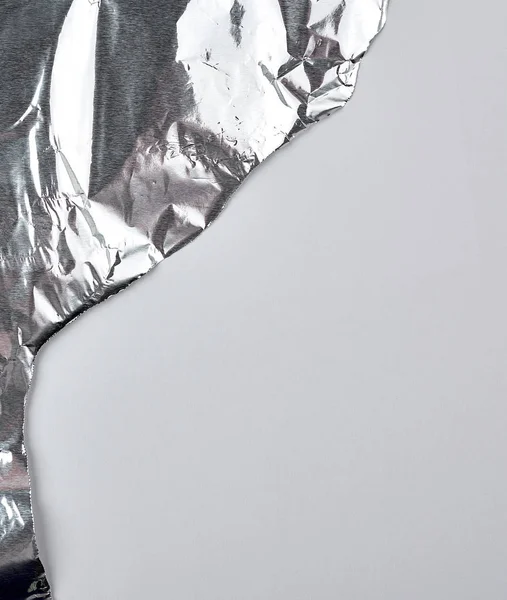 Ragged edge of silver foil on a white background — Stok Foto