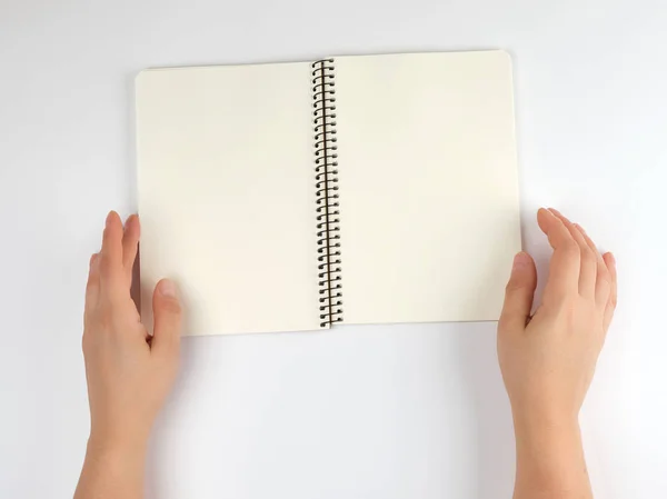 Δύο γυναικεία χέρια κρατώντας ανοιχτό το σημειωματάριο με καθαρά σεντόνια — Φωτογραφία Αρχείου
