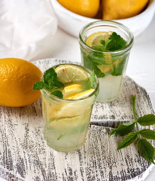 Refrescante bebida limonada con limones, hojas de menta, lima en un gl —  Fotos de Stock