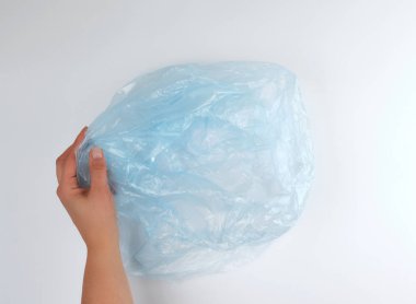 kadın elinde mavi plastik çöp torbası 
