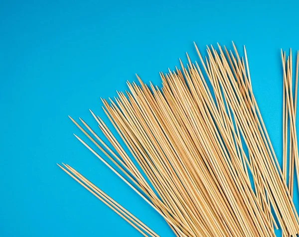 Wooden bamboo sticks on a blue background — Stock Photo, Image