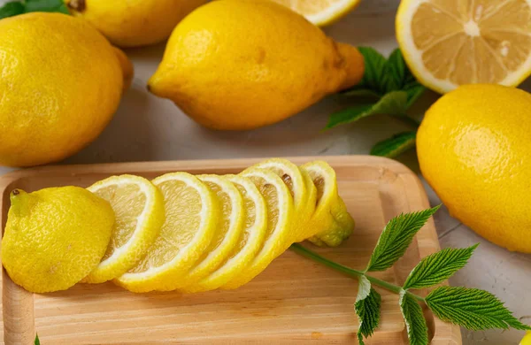 Limoni freschi interi gialli e frutta a fette — Foto Stock