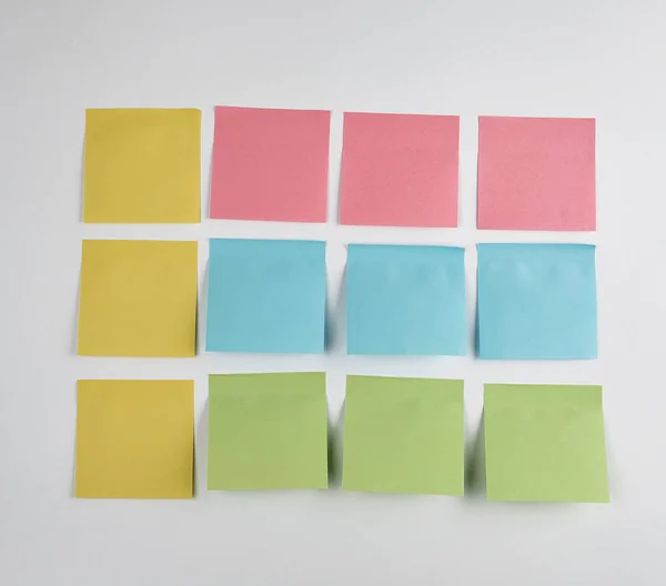 Pegatinas de papel rosa, azul y verde pegadas sobre fondo blanco — Foto de Stock